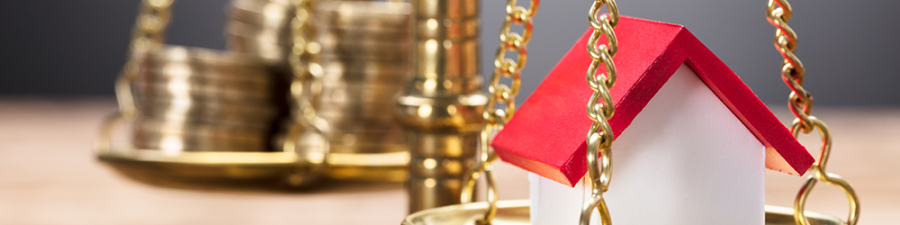 What is a Third Party Legal Charge? A guide from SAM Conveyancing. A small model house sits on one half of a set of brass scales, opposite a stack of golden coins