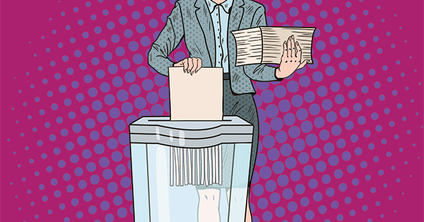 A woman stands by a shredder, shredding an old declaration of trust which has been changed.