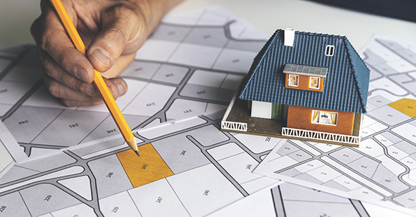 House model sitting on top of title plans. Parachute Law's guide to applying for a Land Registry First Registration