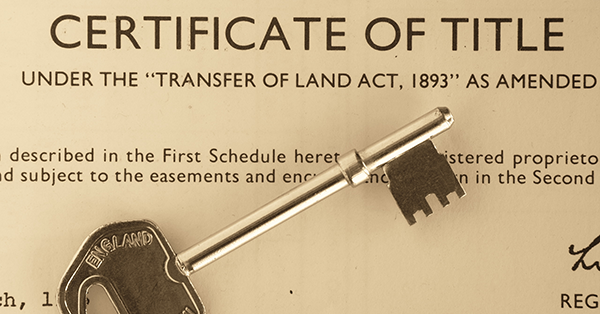 Door key resting on title certificate of a house. Parachute Law Solicitors explains restrictions beginning with 'no disposition of the registered estate'